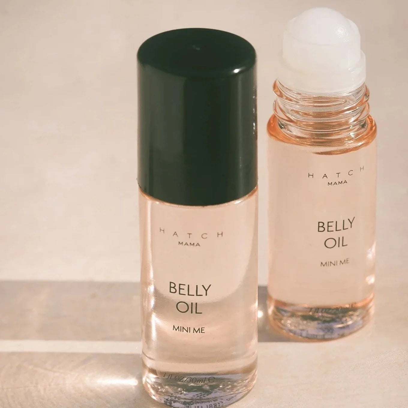 Two bottles of 'Belly Oil' by Hatch Mama on a light background