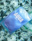 Blue 'Aqua' hydration pack floating in water with a blurred underwater background
