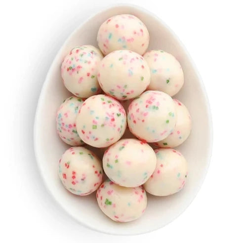 white chocolate balls with colorful sprinkles in them inside white oval dish