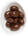 A small white oval dish filled with shiny chocolate-covered pecans, arranged neatly with a glossy surface.