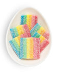 Colorful striped gummy candies on a white plate