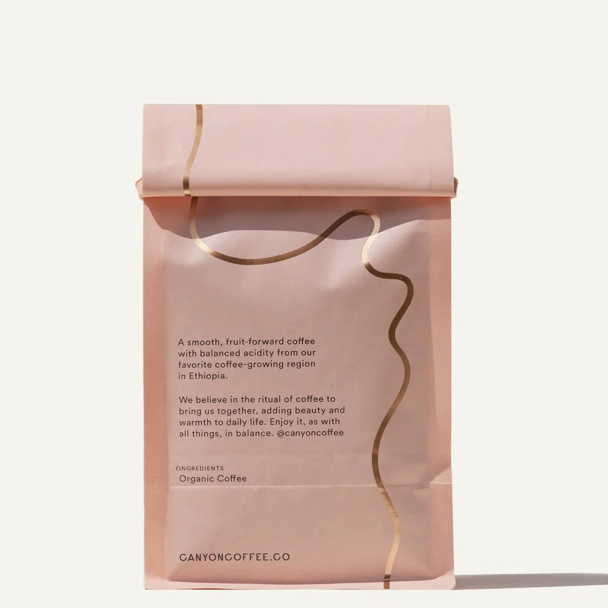 Pink coffee package with text on a light pink background