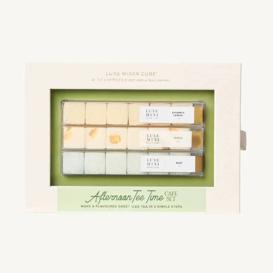 A boxed set of Luxe Mixer Cubes coffee and tea flavoring cubes, featuring a cream-colored outer box with a clear window showing three rows of small flavor cubes, and a green and cream label at the bottom reading 'Afternoon Tea Time CAFE SET'.