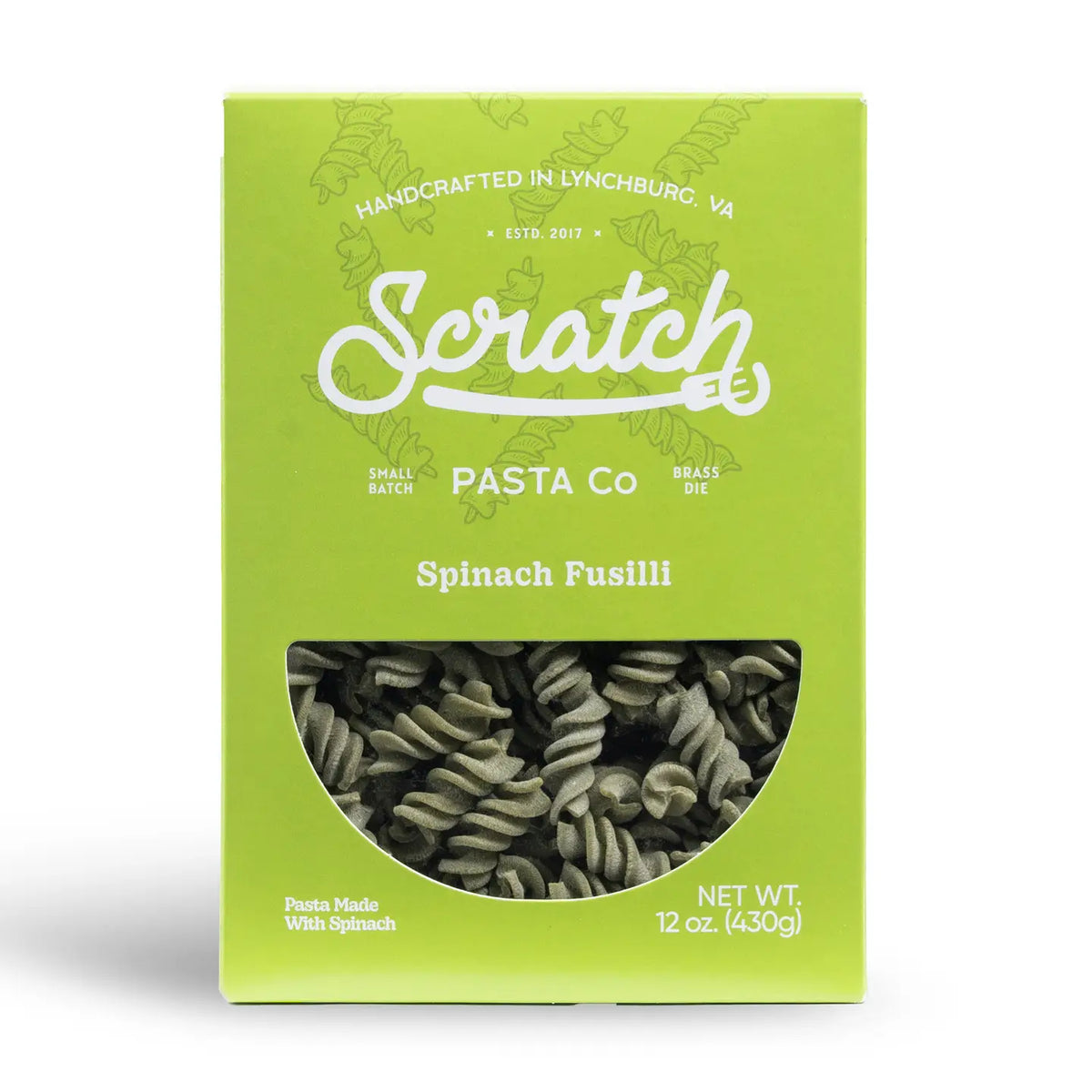 A bright lime green box of Scratch Pasta Co. Spinach Fusilli pasta, featuring a clear window on the front showing the dark green spiral pasta inside.