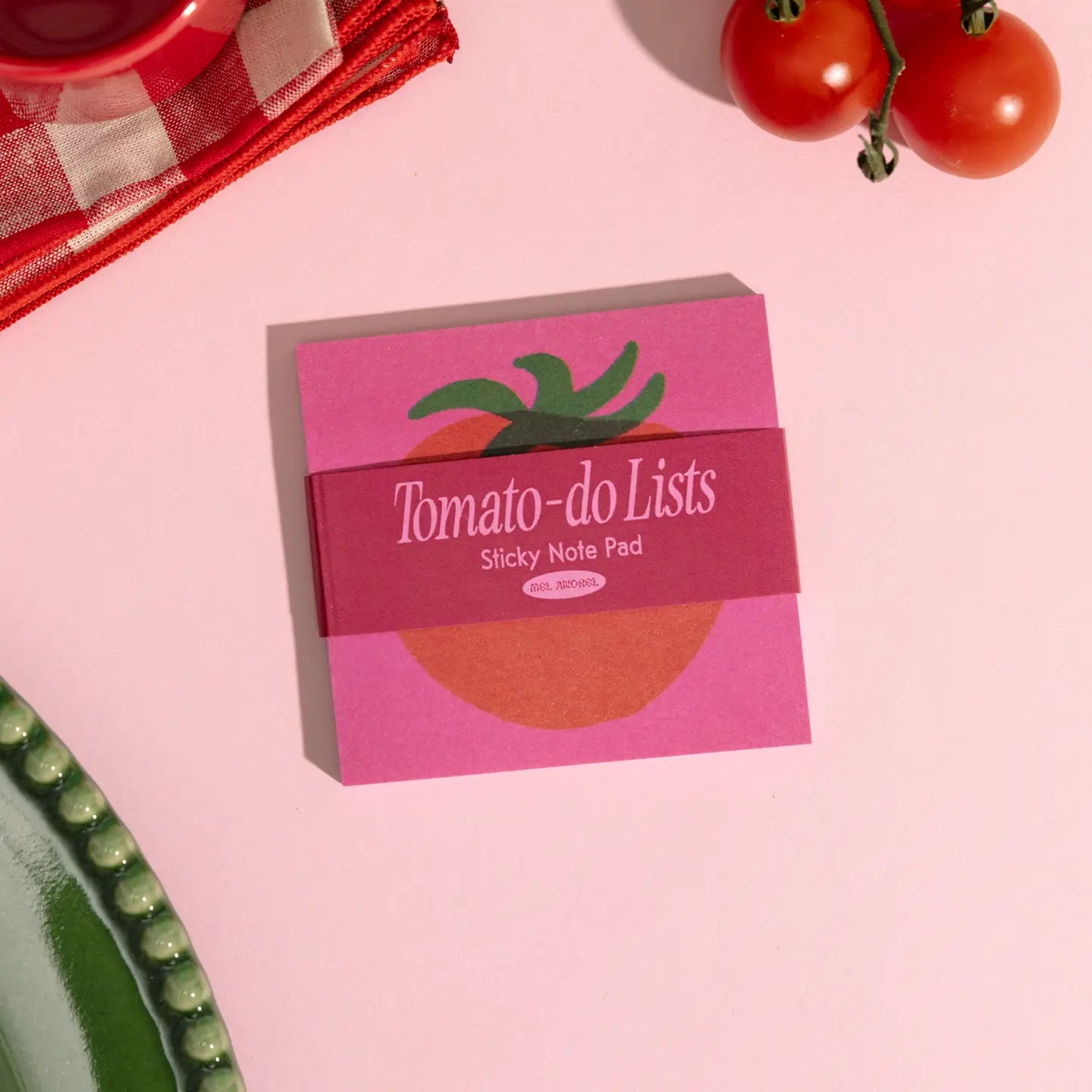Sticky note pad with tomato design on a pink surface