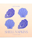A square product box for Piecework Shell Napkins, featuring a light peach background with purple illustrations of two oysters and two scallop shells, and the text 'SHELL NAPKINS' and '4 COCKTAIL NAPKINS'.