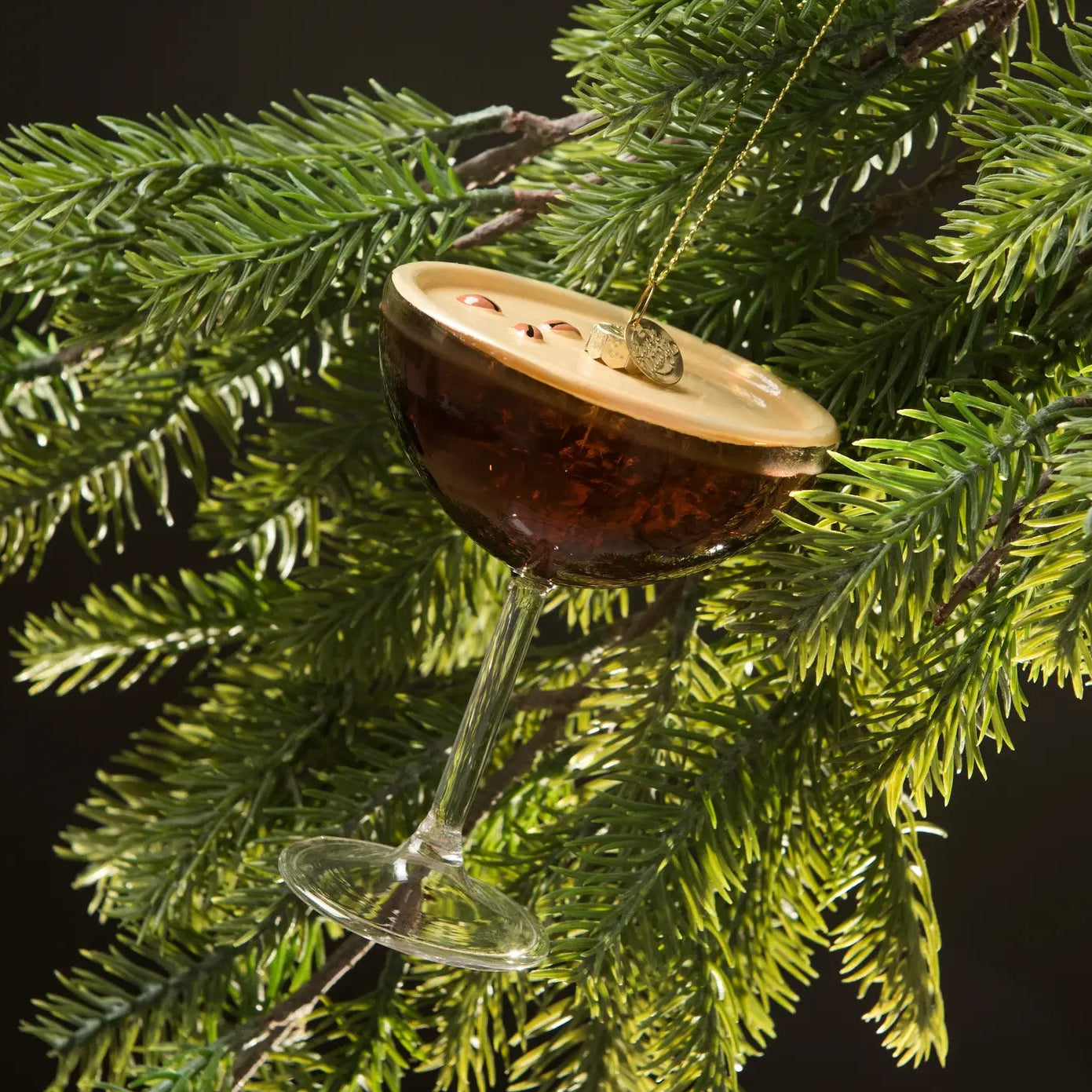 Decorative ornament shaped like a cocktail glass with a slice of lime on a Christmas tree.