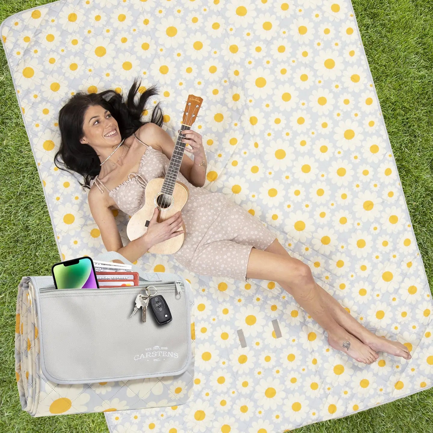 Woman lying on a polka dot blanket holding a guitar, with a Casetify bag and phone nearby.