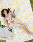 Woman lying on a polka dot blanket holding a guitar, with a Casetify bag and phone nearby.