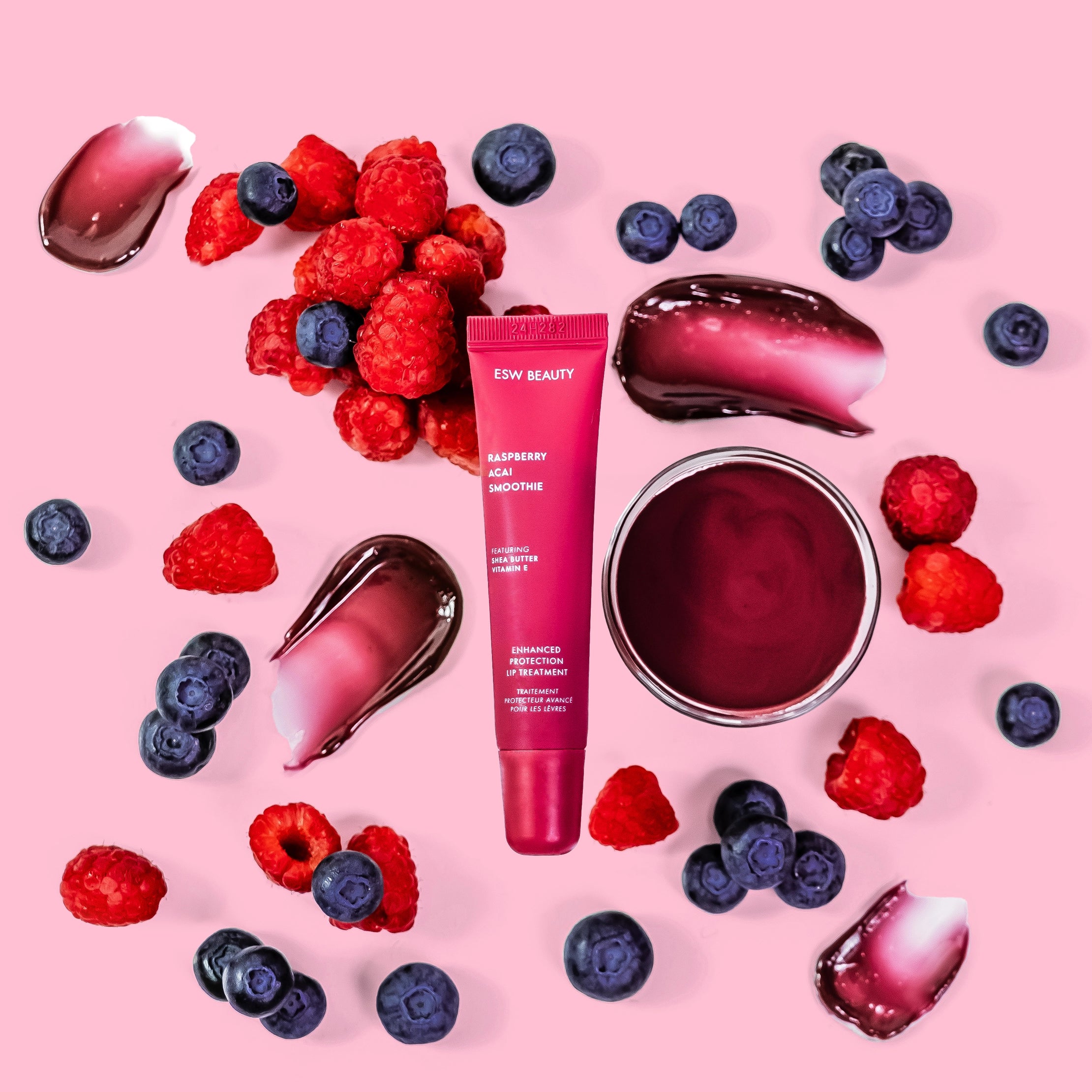 purple lip gloss surrounded by blueberries & raspberries
