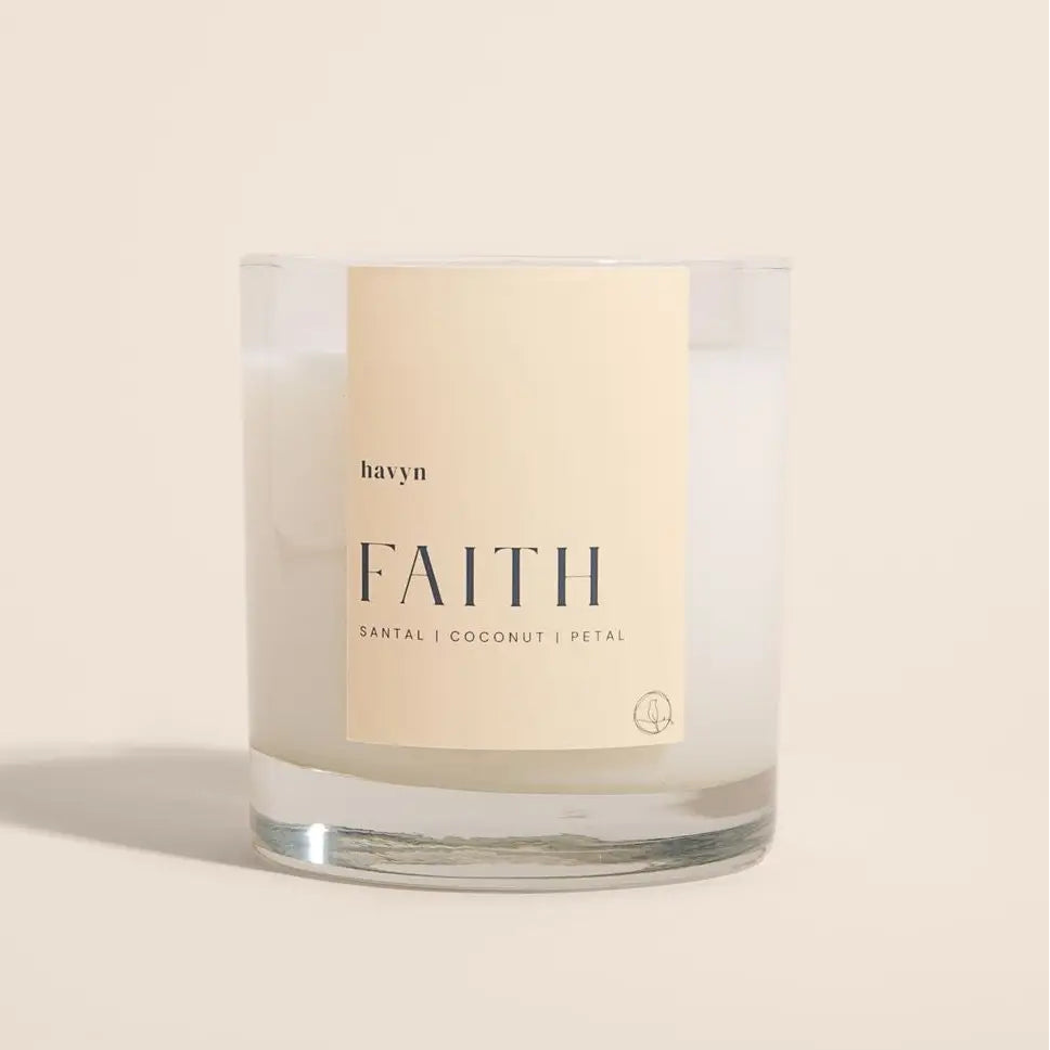 Candle with 'FAITH' branding on a beige background