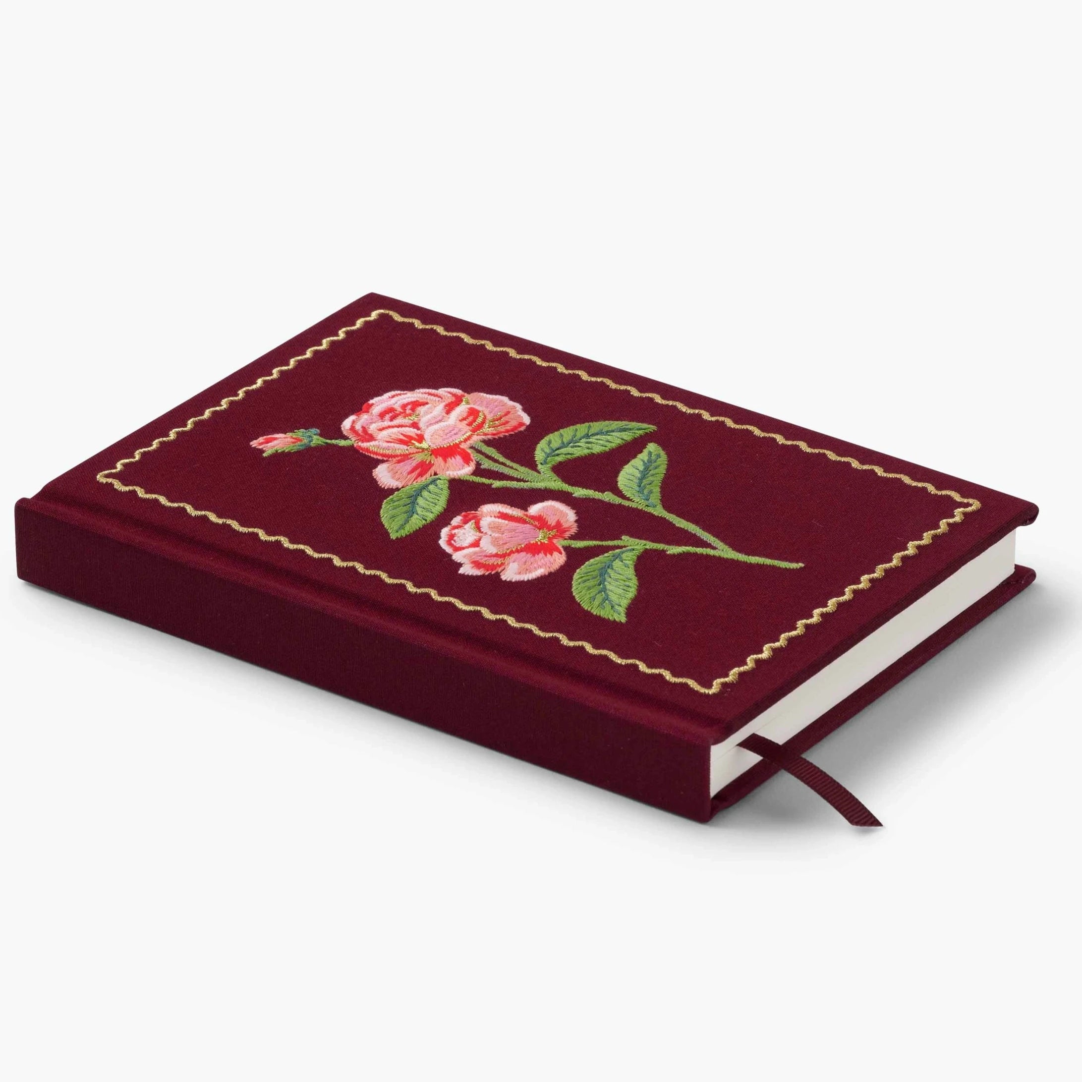 maroon fabric journal with pink roses embroidered on it