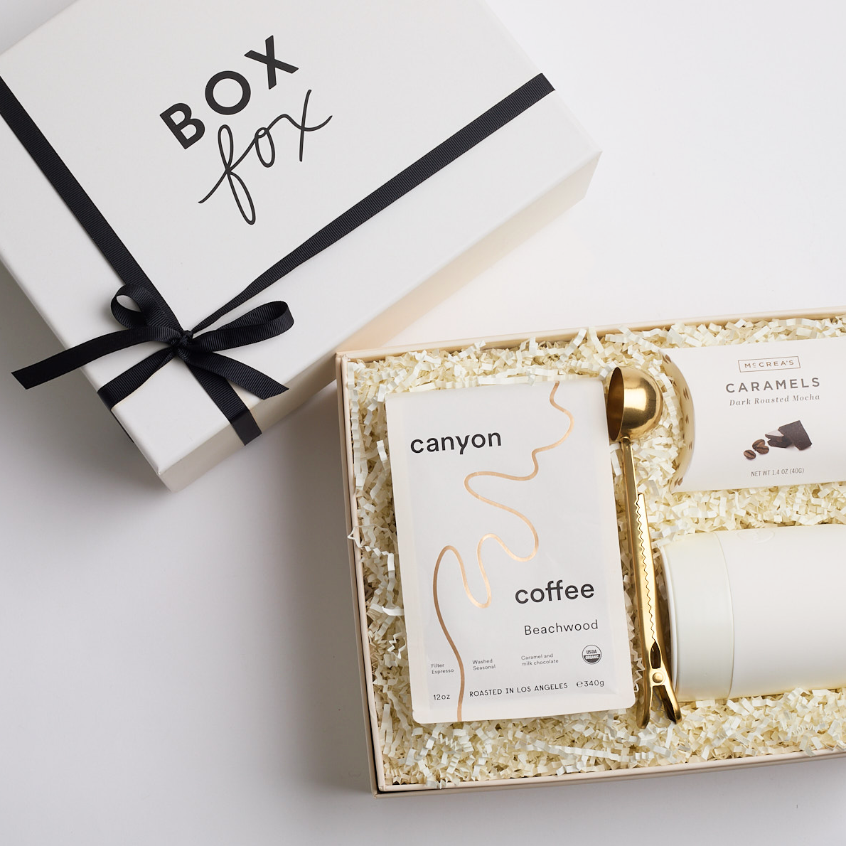 Gold coffee scoop, mocha caramels, cream mug and bag of coffee packed in BOXFOX