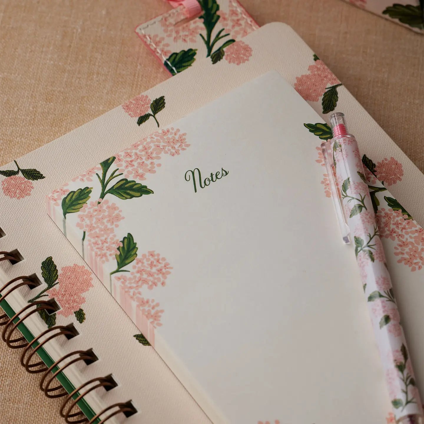Floral notebook with a matching pen on a textured surface