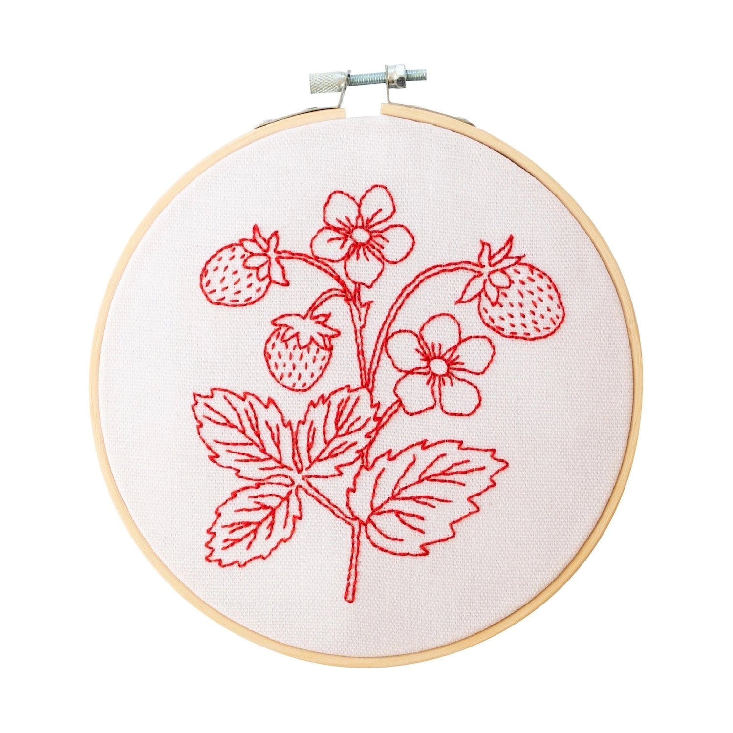 tan hoop with white cloth and red strawberries on stem embroidered on it