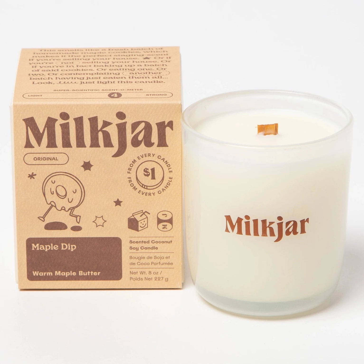 clear glass candle with "MILKJAR" printed on it in brown next to packaging box 