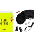 Pouch with "I regret nothing' on the front next to 2 electrolyte tablets, eye mask, 2 pain reliever pills, earplugs, hair tie and breath freshener