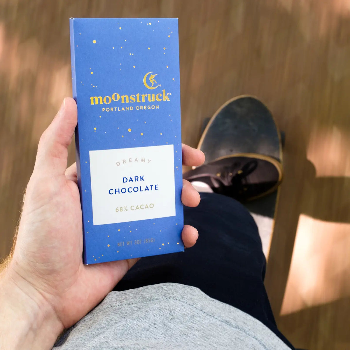 Hand holding a Moonstruck dark chocolate bar packaging