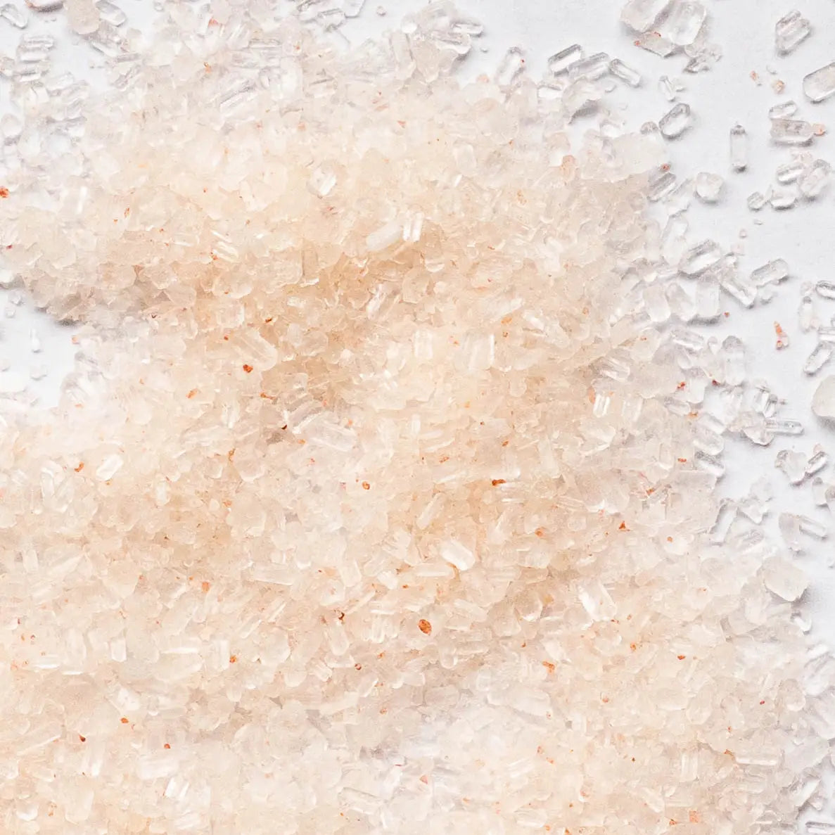 Close-up of pink salt crystals on a white surface