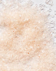 Close-up of pink salt crystals on a white surface