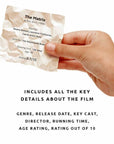 Hand holding a wrapped condom with movie information on a white background