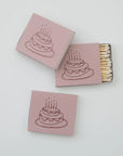 Matchboxes with a cake illustration on pink boxes