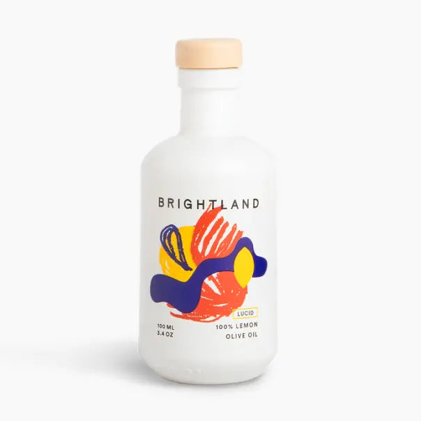 Brightland Lucid 100% Lemon Olive Oil in a white glass bottle with a light wood cap, featuring a colorful abstract label.