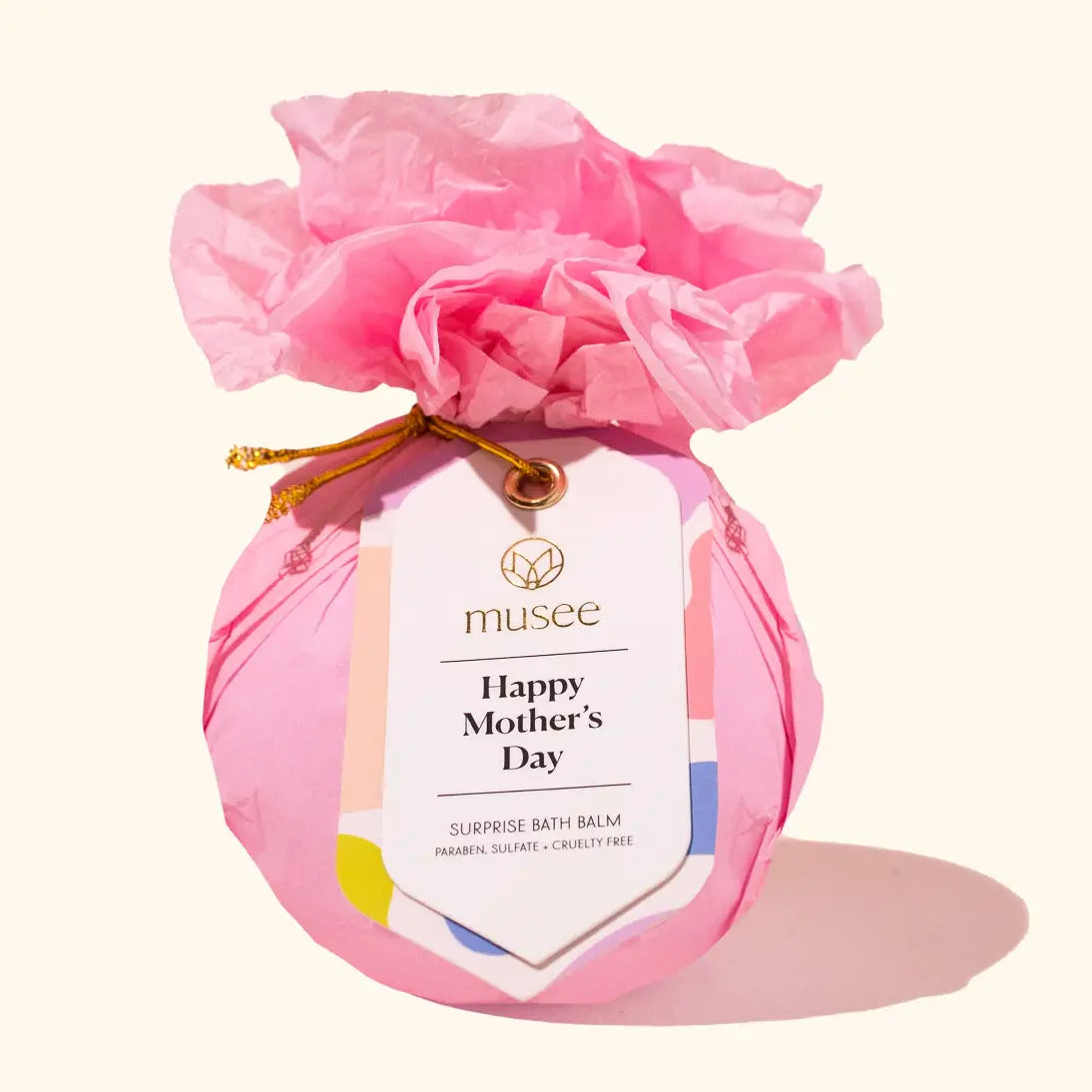 Pink bath bomb with a 'Happy Mother's Day' tag and floral packaging on a white background
