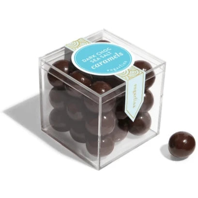 Clear plastic cube with dark chocolate balls inside