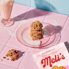 Mel's cookies on a pink plate with a glass of milk in the background