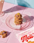 Mel's cookies on a pink plate with a glass of milk in the background