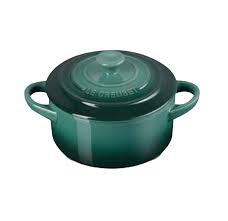Green enameled cast iron round Dutch oven with handles on a white background