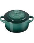 Green enameled cast iron round Dutch oven with handles on a white background