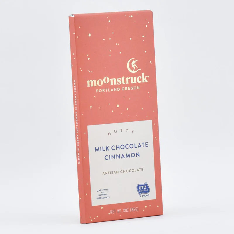 Close up of moonstruck orange milk chocolate cinnamon bar on a white background