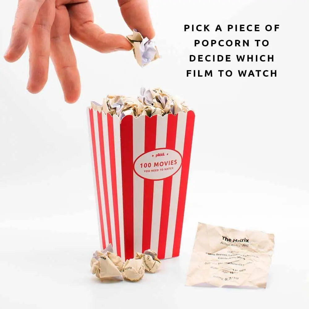 Red and white striped popcorn container with a piece of popcorn being picked, on a white background.