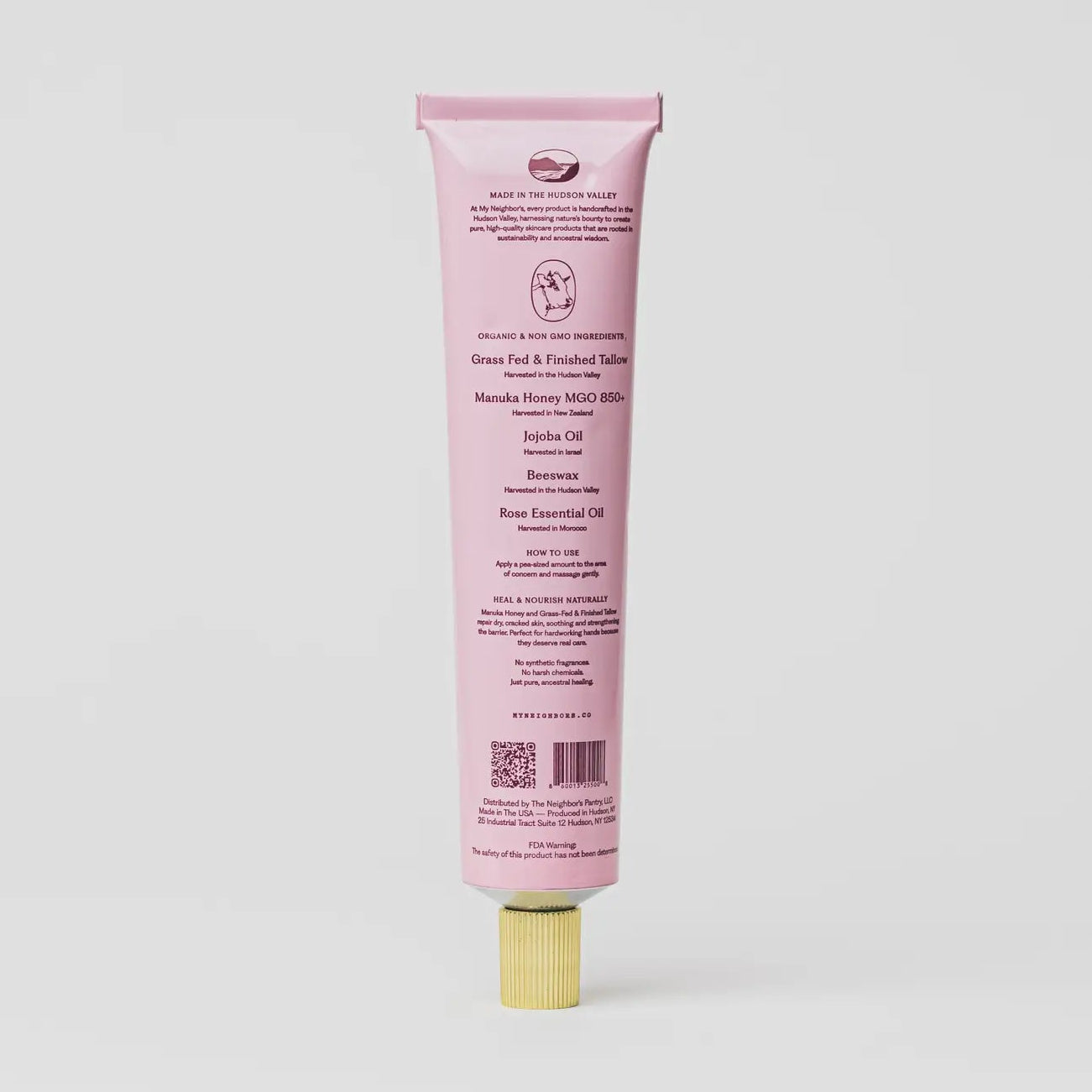 A pink squeeze tube of facial and hand wash with a gold cap, shown from the back on a light gray background.