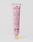 A pink squeeze tube of facial and hand wash with a gold cap, shown from the back on a light gray background.