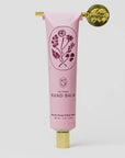 Pink hand balm tube with floral design and gold cap on a white background