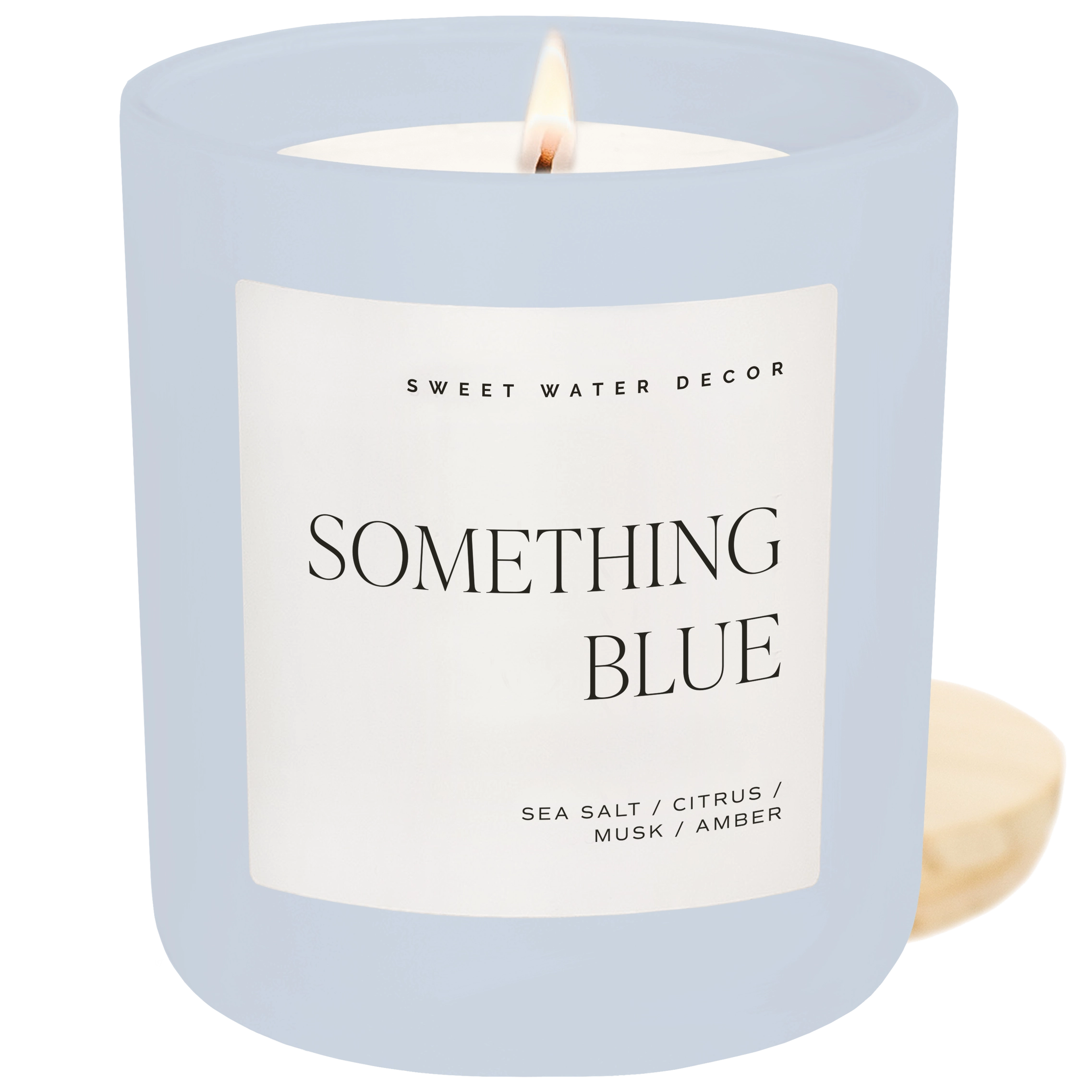 Candle in a light blue jar with a label on a white background