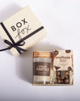 A gift box set on a white background, featuring a cream-colored 'BOX fox' box with a black ribbon, next to an open gift tray containing a candle labeled 'ESPRESSO COFFEE' and a bag of 'craftmix Espresso Martini' chocolates.