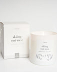 Candle and packaging with 'skiing out west' text on a white background