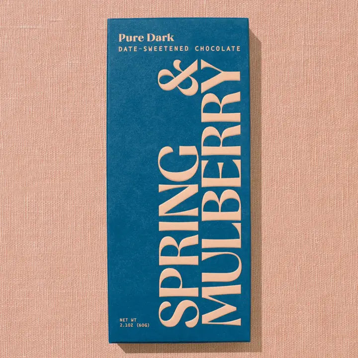 Blue chocolate bar packaging with 'Spring &amp; Mulberry' text on a beige background