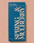 Blue chocolate bar packaging with 'Spring & Mulberry' text on a beige background