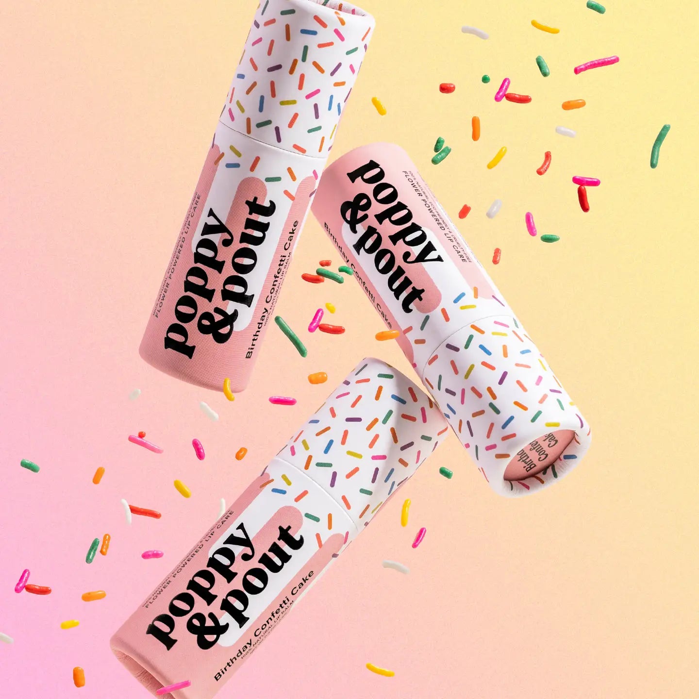 Three 'Poppy &amp; Pout' lip balm tubes with colorful sprinkles on a gradient background