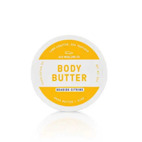 Jar of body butter with a white lid and yellow label on a white background