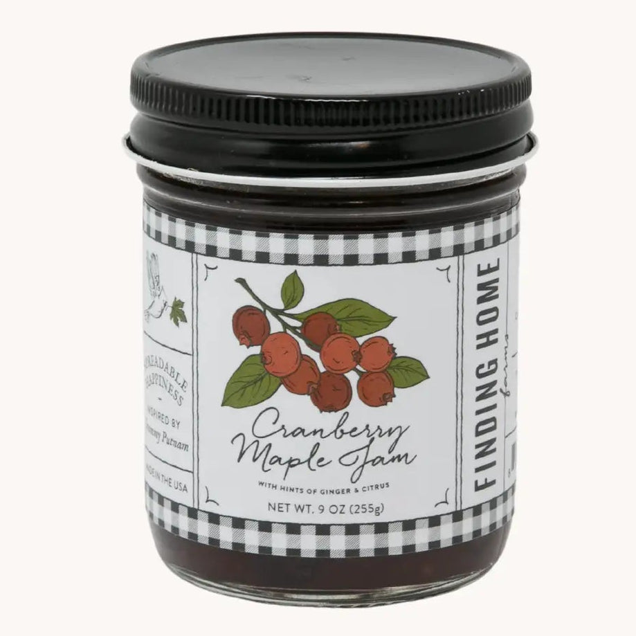 Jar of cranberry maple jam with a label on a white background