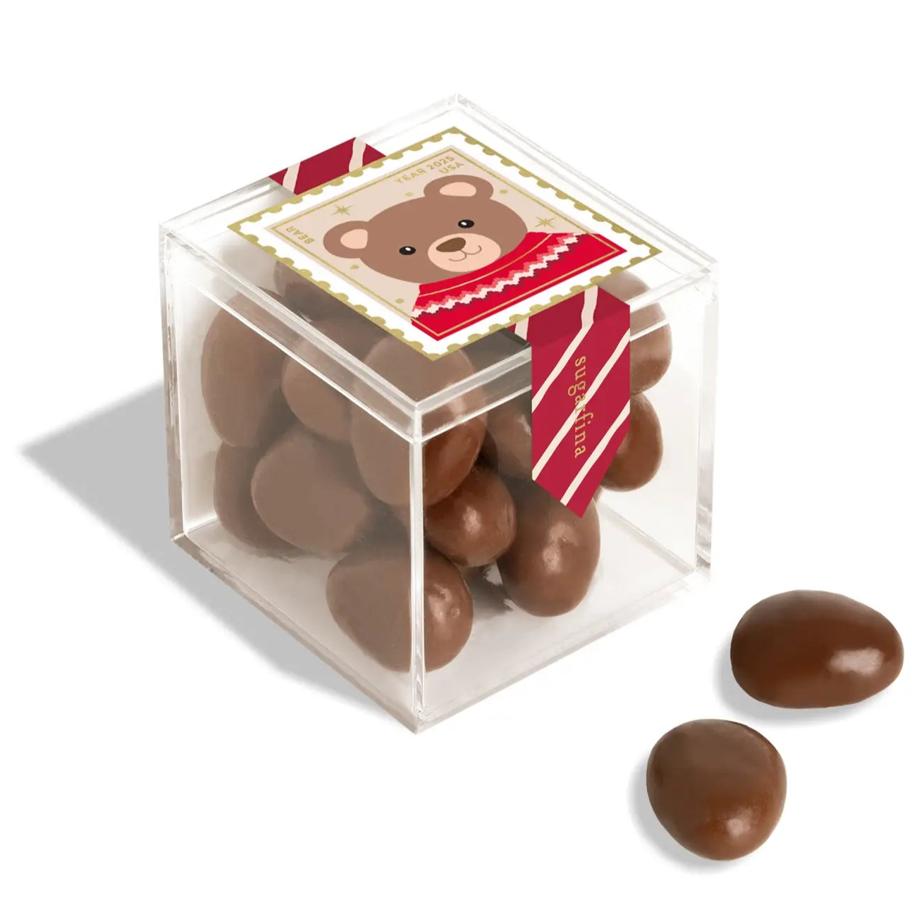 Clear cube box with chocolate eggs and a bear-themed label on a white background