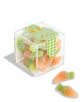 Clear cube container filled with gummy candies shaped like carrots and turtles, with a green bunny on top.