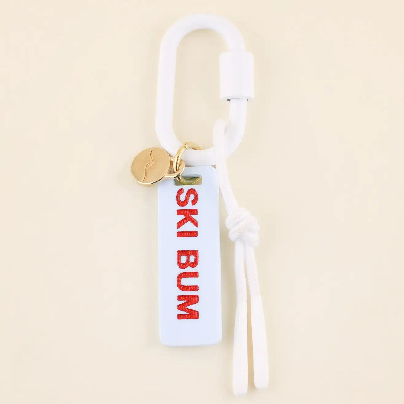 Keychain with 'SKI BUM' tag on a beige background
