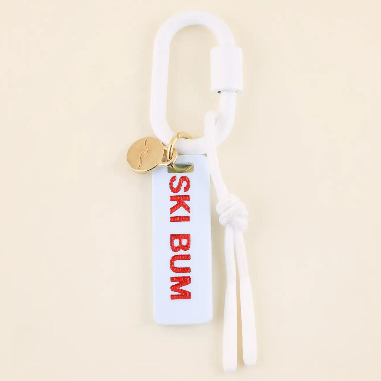 Keychain with 'SKI BUM' tag on a beige background